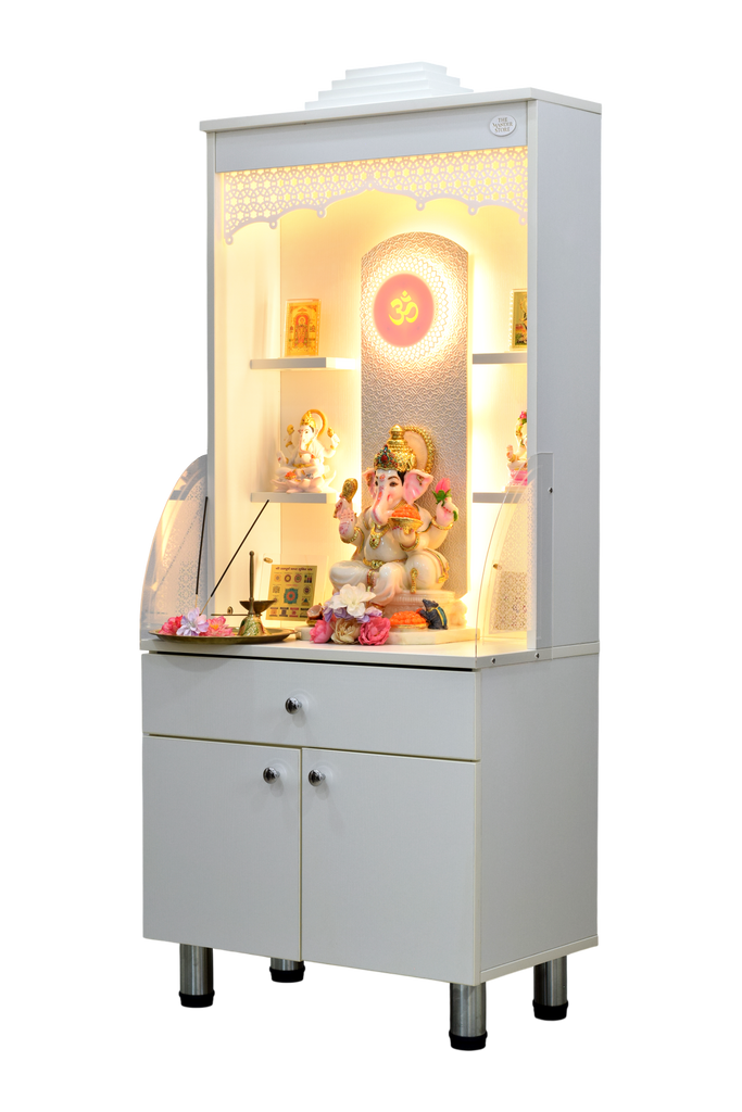 Front view of wooden mandir with religious idols displayed on shelves with floral decorations, lights off